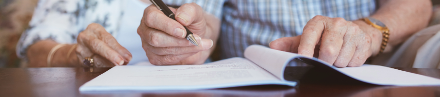 Elderly couple signing document will inheritance planning